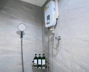 a shower with three bottles of wine in a bathroom at Baan Nonzee Condo Kingsize bed Big room in Sathorn in Bangkok