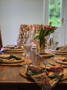 a wooden table with plates of food and wine glasses at Oak Tree Cottage in Lincolnshire