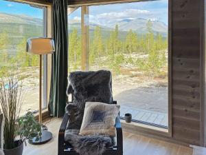einen Stuhl in einem Zimmer mit einem großen Fenster in der Unterkunft Holiday home Sollia in Brenn
