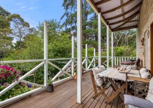 eine Veranda mit einem Tisch und Stühlen auf einer Terrasse in der Unterkunft Blue Country Lodge in Katoomba