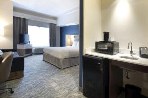 サバンナにあるSpringHill Suites Savannah Airportのベッドと電子レンジ付きのホテルルーム