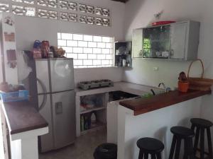una cocina con nevera y algunos taburetes. en Hospedaje casa completa Honda Tolima, en Honda