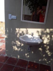 a woman taking a picture of a sink in a bathroom at Hospedaje casa completa Honda Tolima in Honda