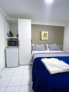 una piccola camera con 2 letti e un forno a microonde di Acomodação aconchegante à beira- mar a Natal