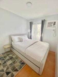 Schlafzimmer mit einem Bett und einem Fenster mit einem Ventilator in der Unterkunft MQ Staycation at One Oasis in Cagayan de Oro