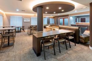 a restaurant with tables and chairs and a bar at SpringHill Suites Rochester Mayo Clinic Area / Saint Marys in Rochester