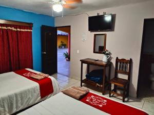 een slaapkamer met een bed, een bureau en een spiegel bij Hotel Posada Santa Elena in Parras de la Fuente