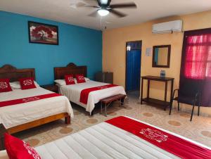 - une chambre avec 2 lits et un ventilateur de plafond dans l'établissement Hotel Posada Santa Elena, à Parras de la Fuente