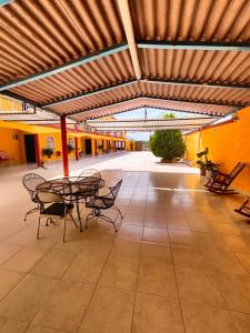 un patio avec des tables et des chaises dans un bâtiment dans l'établissement Hotel Posada Santa Elena, à Parras de la Fuente
