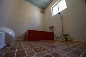 a bathroom with a toilet and a window and a tub at 日向サーフキャンプ211 in Hyuga