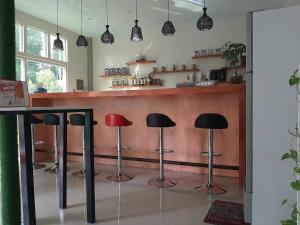 a bar with red and black stools in a kitchen at Casa Michabella Leisure and Events Place in Supa