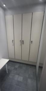 a room with four white lockers in a room at BeautyD RED ROOM centrum Gullegem in Wevelgem