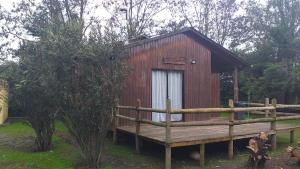 una piccola cabina in legno con un ponte di legno di fronte ad essa di Cabañas Rusticas ElAire 