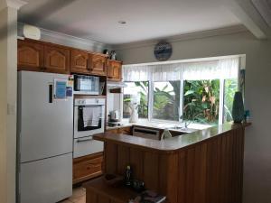 uma cozinha com um frigorífico branco e um lavatório em Mudjimba Esplanade Villa em Mudjimba