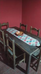 a wooden table with chairs and a bowl on it at Alojamiento Alquiler Temporario in Las Flores