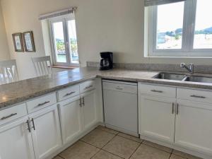 kuchnia z białymi szafkami i zlewem w obiekcie Harbour View Penthouse w mieście Gros Islet