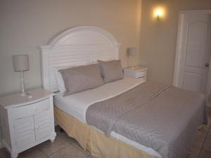 una camera con un grande letto con testiera bianca di Harbour View Penthouse a Gros Islet Altre 15 foto