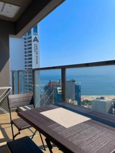 a balcony with a table and a view of the ocean at ElbonThe Beach Haeundae in Busan