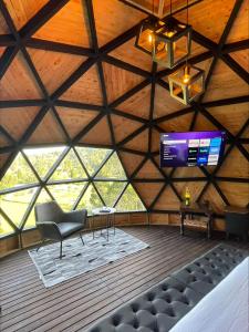 Habitación con silla y TV en el techo. en Entre-pinos Glamping WiFi Vista 360º, en Guarne