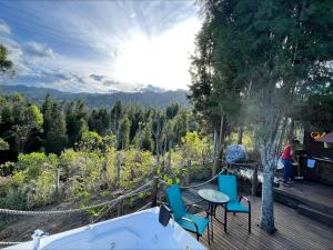 - Terraza con sillas, mesa y bañera en Entre-pinos Glamping WiFi Vista 360º, en Guarne