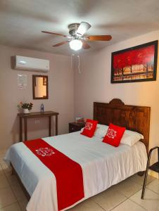 Un dormitorio con una cama con almohadas rojas. en Hotel Posada Santa Elena en Parras de la Fuente