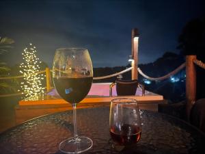 a glass of wine sitting on top of a table at Entre-pinos Glamping WiFi Vista 360º in Guarne