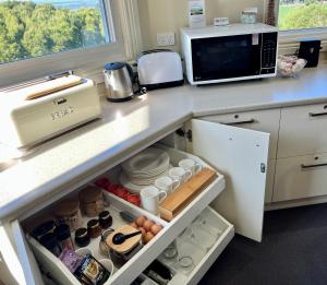 a kitchen with a counter with a refrigerator and a microwave at Llarrinda Bed & Breakfast in Foster