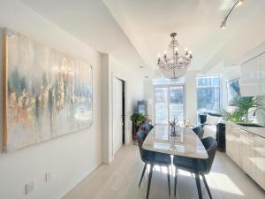 a dining room with a table and chairs and a chandelier at Boutique Penthouse-Live in the SKY with Amazing Lakeview! Downtown Toronto!B in Toronto