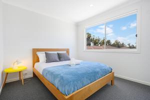 a bedroom with a bed and a window at Denham Court Adorable 4Br house with Wifi &Parking in Horningsea Park