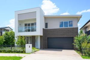 a white house with a garage at Denham Court Adorable 4Br house with Wifi &Parking in Horningsea Park