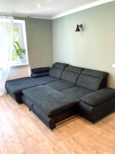 a large blue couch in a living room at Grīzupes apart in Liepāja