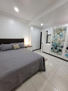 um quarto com uma cama e um quadro na parede em Chalet Belizomi Tropical Villa #1 em Gros Islet