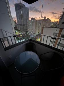 a balcony with a table and a view of a city at Apto Brooklin ao lado do metro in Sao Paulo