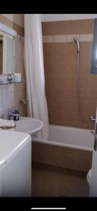 y baño con ducha, bañera y lavamanos. en Lefkas Apartment, en Lefkada