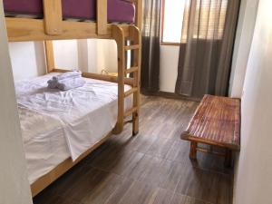 曼科拉的住宿－La Casa de Don Javier，一间卧室配有两张双层床和一张长凳。