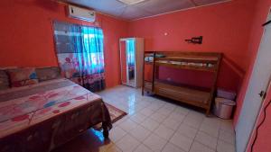1 dormitorio con paredes rojas, 1 cama y ventana en Beautiful 1-Bedroom in St Thomas Jamaica en Belfast