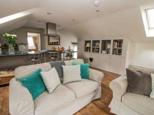 a living room with a couch and a kitchen at The Barn in Preesgreen