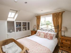 a bedroom with a bed and a chair and a window at The Barn in Preesgreen