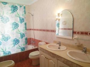 a bathroom with a sink and a toilet and a mirror at Independiente estudio en acogedora casita de Mai in Adeje +37 photos