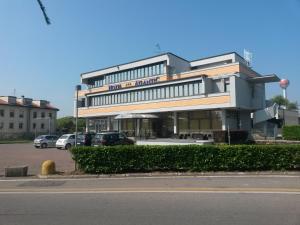 un gran edificio con coches estacionados en un estacionamiento en Hotel Meuble' Atlantic, en Treviglio