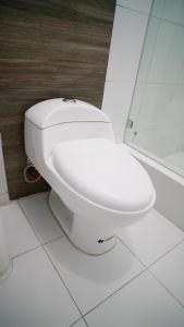 um WC branco numa casa de banho com chuveiro em Casa Umiña Boutique Hotel Manta em Manta