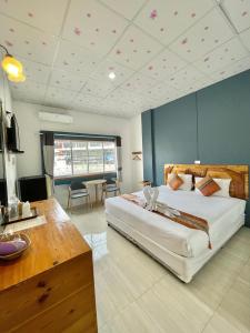 ein großes Schlafzimmer mit einem großen Bett und einem Schreibtisch in der Unterkunft Diamond de pai in Pai