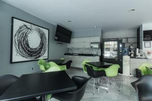 a kitchen with a black table and green chairs at HOTEL LEMON GREEN -Zona Expo Frente al Centro de Convenciones in Guadalajara