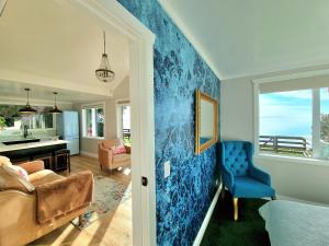 a living room with a blue accent wall at Red Rock Cottage, beachfront luxury in Clarks Beach
