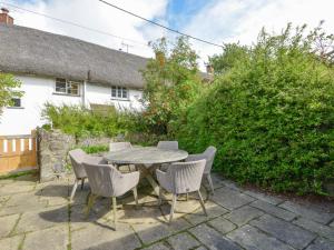 un patio con mesa y sillas frente a una casa en Rookwood, en Exeter