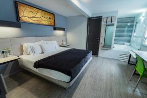 um quarto com uma cama e uma casa de banho com uma banheira em HOTEL LEMON GREEN -Zona Expo Frente al Centro de Convenciones em Guadalajara