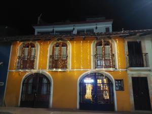 a yellow building with barred windows at night at HOTEL PUEBLO BONITO in Zacatlán