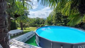 una grande piscina in un cortile alberato di Villa Pusiana a Cesana Brianza