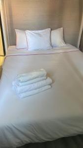 uma cama branca com três toalhas em PARAISO Da PENHA em Lisboa