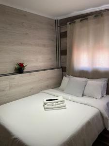 uma cama branca com duas toalhas em cima em PARAISO Da PENHA em Lisboa